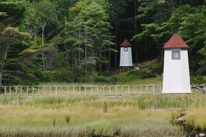 small lighthouses on shoreline against forest as can be seen on a Harbor Cruise
